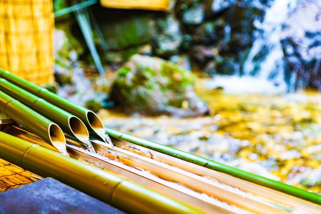 bamboo chutes for nagashi soumen with waterfall in background