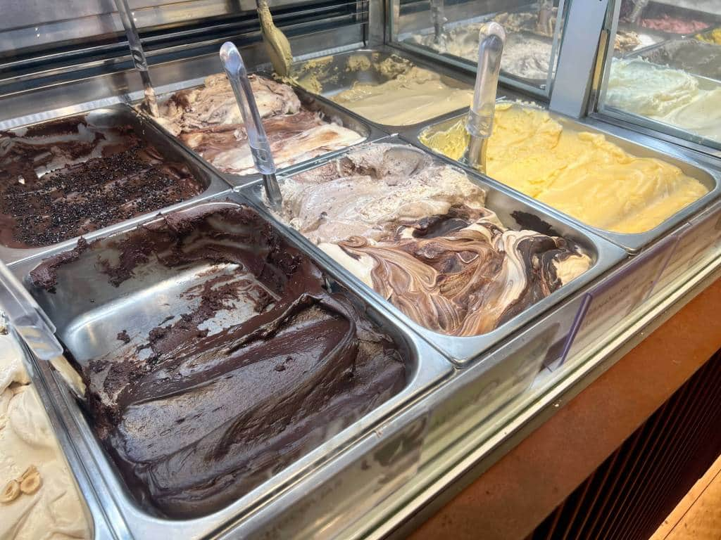 A mix of gelato flavors in serving pans