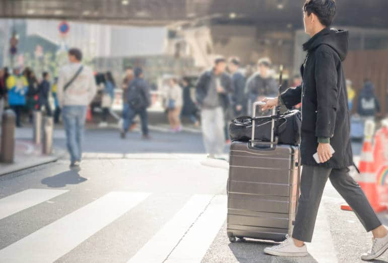 Young asian man looking for travel location using mobile phone and spending time to travel in asia