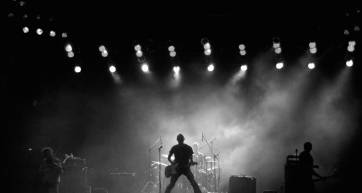 man with guitar on stage at a rock festival