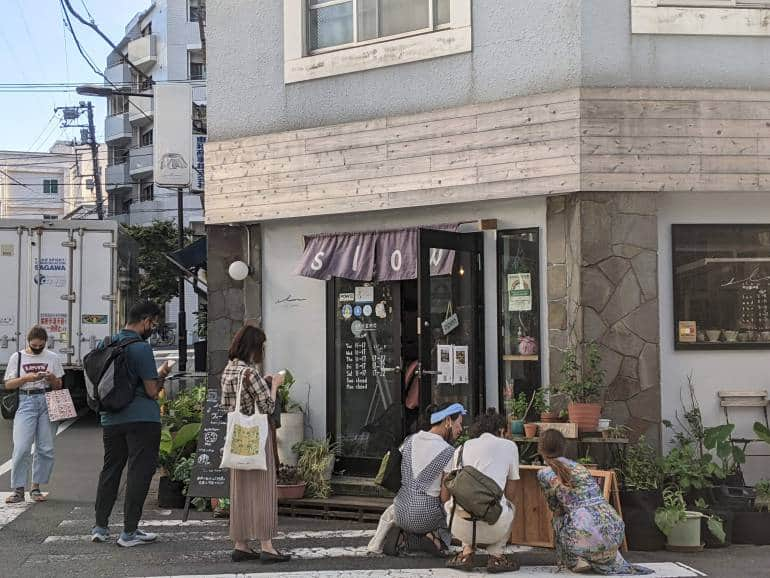 Customers wait outside a cafe called Slow Ecolab