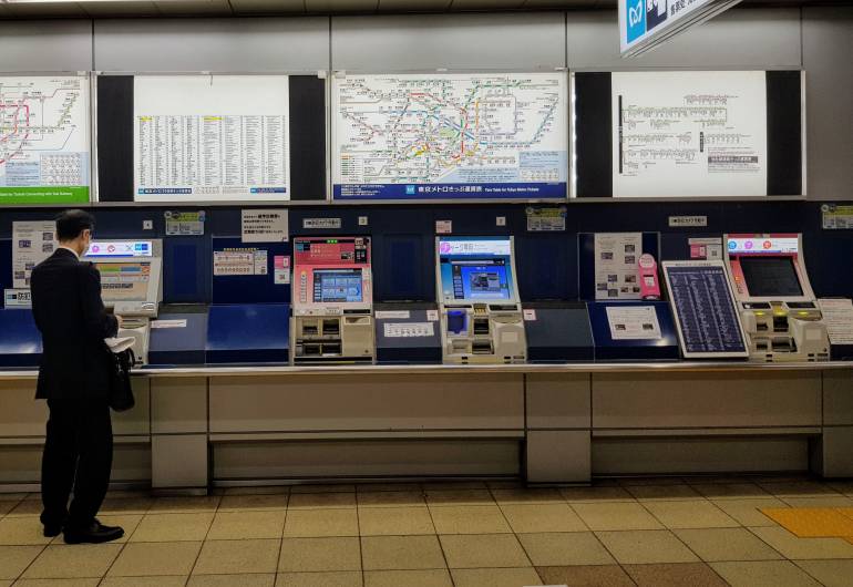 An array of ticket machines below a network map at Tokyo Metro Akasaka Station