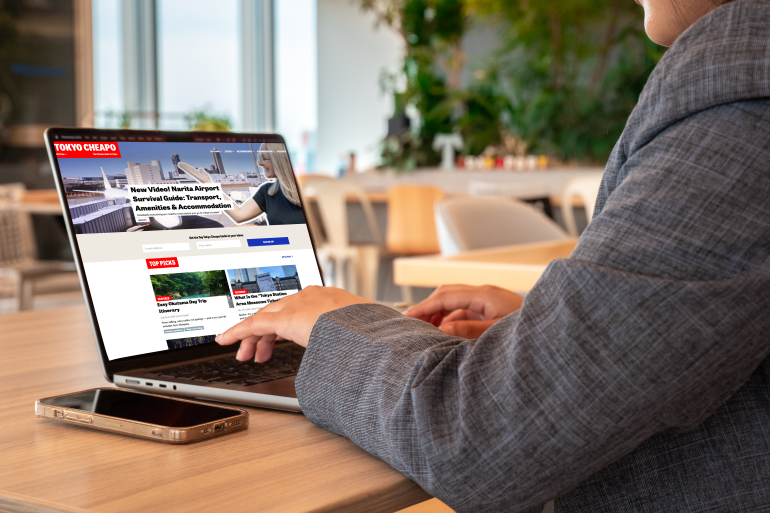 A woman in business attire works at her laptop. A phone with an eSIM installed sits next to her.